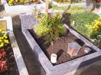 Grabmal aus Naturstein mit Blumen