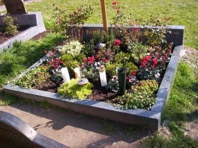 Grabmal aus Naturstein mit Blumen